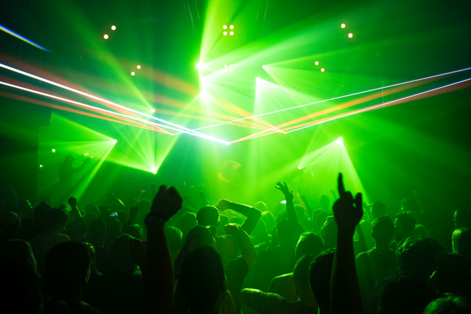 Dancefloor con laser verdi e folla che balla
